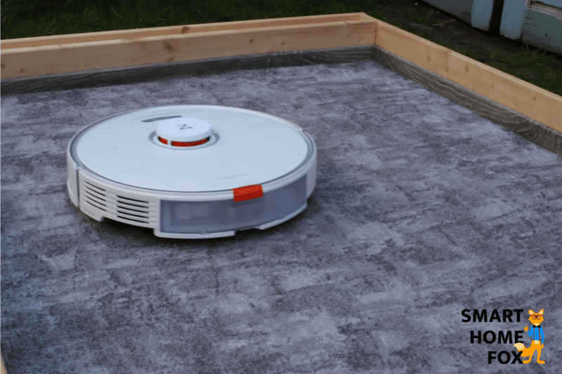 Roborock S7 reinigt Sand auf einem niedrigen Teppich